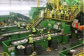 workers on conveyor belt separating materials at a materials recovery facility (MRF)